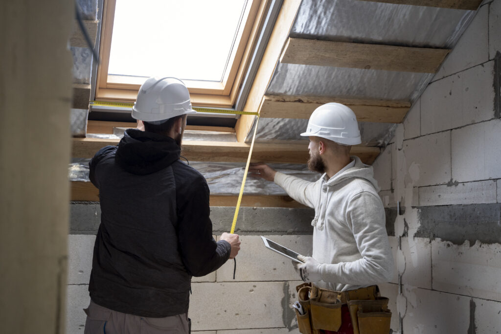 Deux hommes réalisant des travaux d'isolation dans une maison ,pour réduire la facture énergétique
